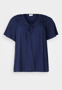 Haut à manches courtes bleu marine en tissu doux, avec des détails plissés aux épaules et un ruban au niveau du col pour un ajustement réglable.