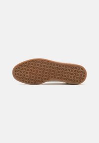 Kumimaton sneaker-pohja, jossa on teksturoitu kuvio geometrisista muodoista. Väri: ruskea. Litteä, pyöristetty profiili ja kestävä rakenne.