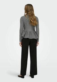 Siv svetrov peplum v rebrasti teksturi z oprijetim delom, v kombinaciji s črnimi širokimi hlačami in črnimi ravnimi čevlji.