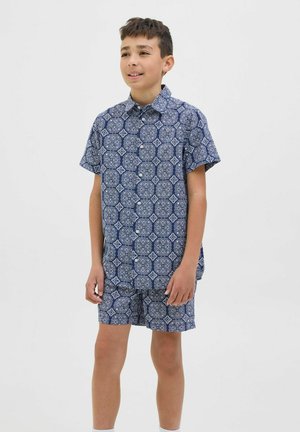 Kortärmad skjorta med knappar och matchande shorts i marinblått med intrikata vita geometriska mönster. Lättviktsmaterial, avslappnad passform.