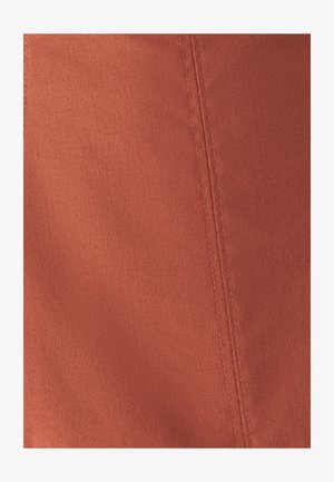 Terrakotta-Stoff mit glatter Textur, der eine auffällige Naht entlang der Kante aufweist. Schlichte, schmucklose Oberfläche ohne Muster.