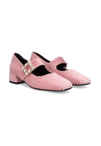 Zapatos Mary Jane de terciopelo rosa con textura acanalada, que presentan una correa con hebilla adornada con piedras preciosas y un tacón bajo.