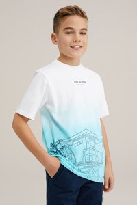 Balts kokvilnas T-krekls ar zilu krāsu gradientu, kurā ir līnijgrafikas attēlojums no mājas un palmu kokiem, ar apaļu kakla izgriezumu un īsām piedurknēm.