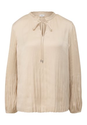 Blouse beige à manches longues avec des plis verticaux, un décolleté à trou clé avec un lien décoratif, et des poignets froncés. Texture lisse ressemblant à du satin.