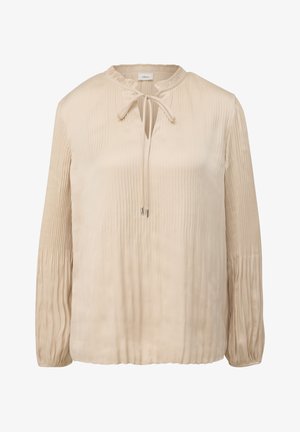 Blouse beige à manches longues avec des plis verticaux, un décolleté à trou clé avec un lien décoratif, et des poignets froncés. Texture lisse ressemblant à du satin.