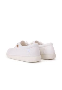 White canvas sneakers with a round toe, rubber sole, and decorative wooden accents. Smooth texture with minimal stitching.