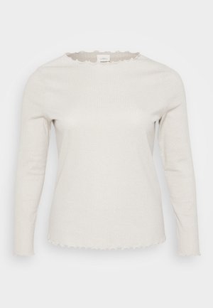 Hellbeige Langarmshirt aus geripptem Stoff. Mit einem gewellten Ausschnitt und leicht fransenden Kanten an den Ärmeln und dem Saum.