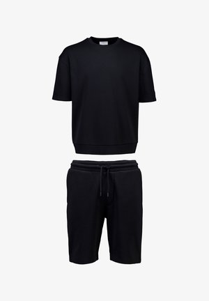Czarna bluza z krótkim rękawem z prążkowanym dołem, zestawiona z czarnymi szortami ze sznurkiem, prezentowana na białym tle.