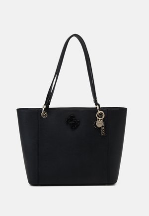 Black tote handbag with double shoulder straps, gold-tone metal accents, and a decorative Guess logo charm on the front.