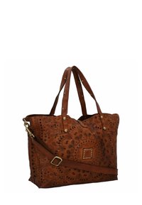 Borsa a tote grande in pelle marrone con motivi intagliati intricati, due manici superiori e una tracolla regolabile. Presenta borchie decorative.