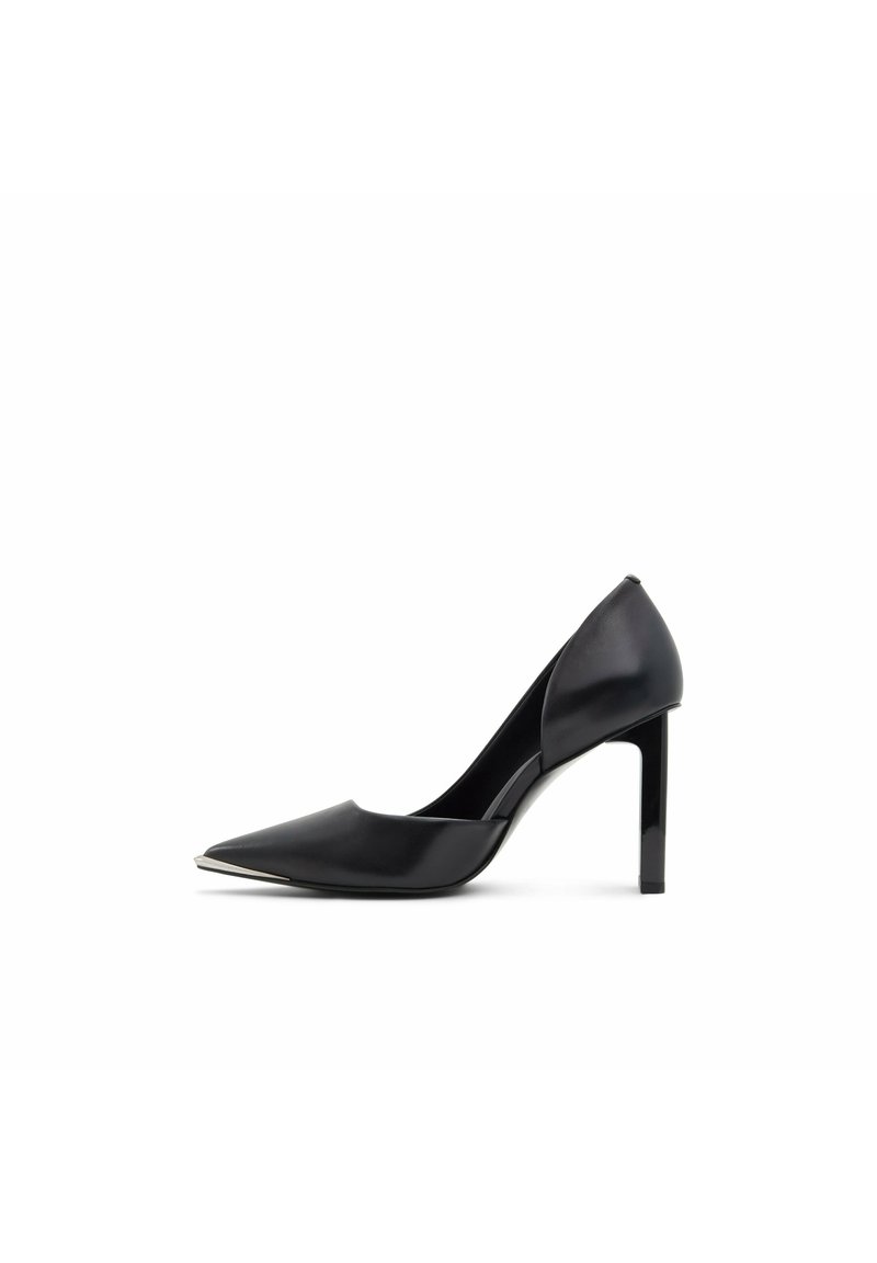 Escarpin à talon haut en cuir noir avec bout pointu, découpe sur le côté et un accent métallique à l'avant. Dispose d'un talon aiguille élancé.