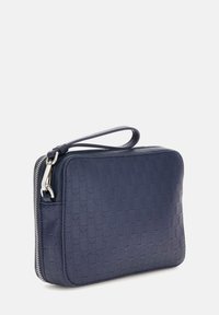Geantă bleumarin cu fermoar, fabricată dintr-un material texturat cu un model în formă de zigzag embosat, având un mânere lateral și accesorii din argint.
