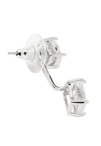 Srebrna kolczyk z prostokątnym, przezroczystym kamieniem osadzonym w geometrycznym wzorze, połączony zakrzywionym słupkiem i metalowymi akcentami.