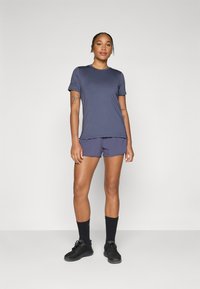 Navy athletic t-shirt and matching shorts, made of smooth fabric. Features short sleeves and a simple design, paired with black sneakers and socks.