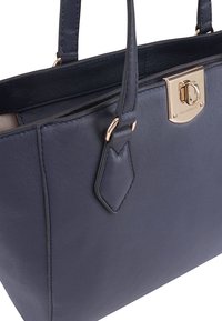 Marineblauwe leren totebag met een gladde textuur, gouden hardware en een veilige sluiting. Beschikt over twee stevige handvatten en een gestructureerd ontwerp.