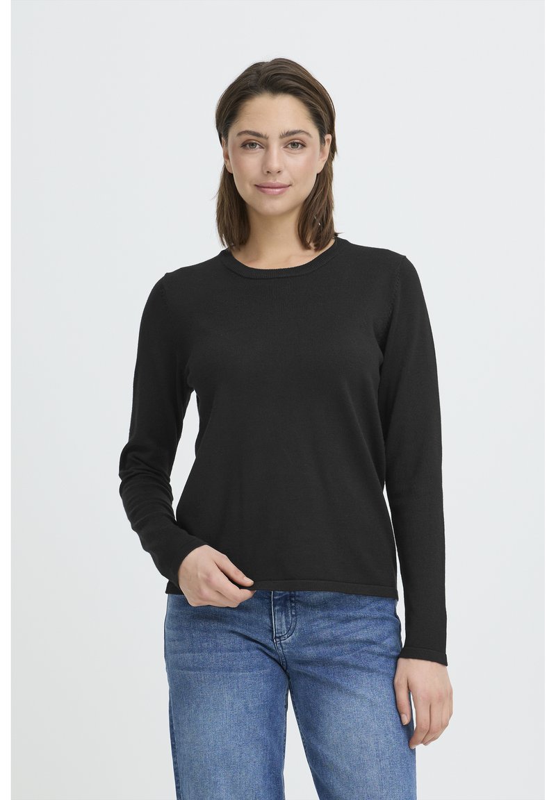 Haut noir à manches longues avec un col rond. Texture douce et lisse avec une coupe ajustée, associé à un jean en denim bleu clair.