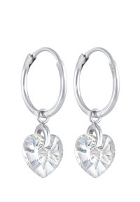 Sølv øreringe med klare hjerteformede krystaller hængende fra en metalring. Krystallerne har facetter, der reflekterer lyset.