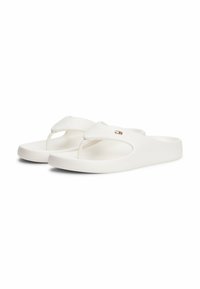 Chanclas blancas de material suave con suela gruesa, que presentan una correa en forma de V y un pequeño acento decorativo con logotipo.