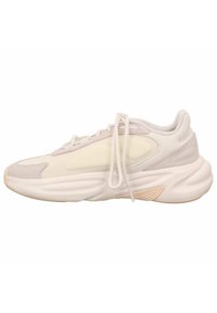 Sneaker z jasnobeżową i kremową siateczką na cholewce, gumową podeszwą, wyściełanym kołnierzem i ozdobnymi detalami ściegów. Sznurowadła w klasycznym stylu.