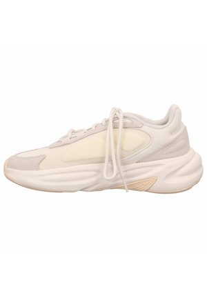 Sneaker z jasnobeżową i kremową siateczką na cholewce, gumową podeszwą, wyściełanym kołnierzem i ozdobnymi detalami ściegów. Sznurowadła w klasycznym stylu.