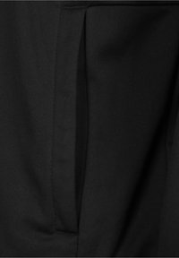 Black fabric showing a textured area with a visible pocket seam, featuring smooth, soft material and a consistent matte finish.