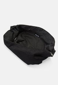 Saco de veludo cotelê preto com fecho de zíper, possui um forro interior suave, etiqueta de marca dentro e forma estruturada e suave.
