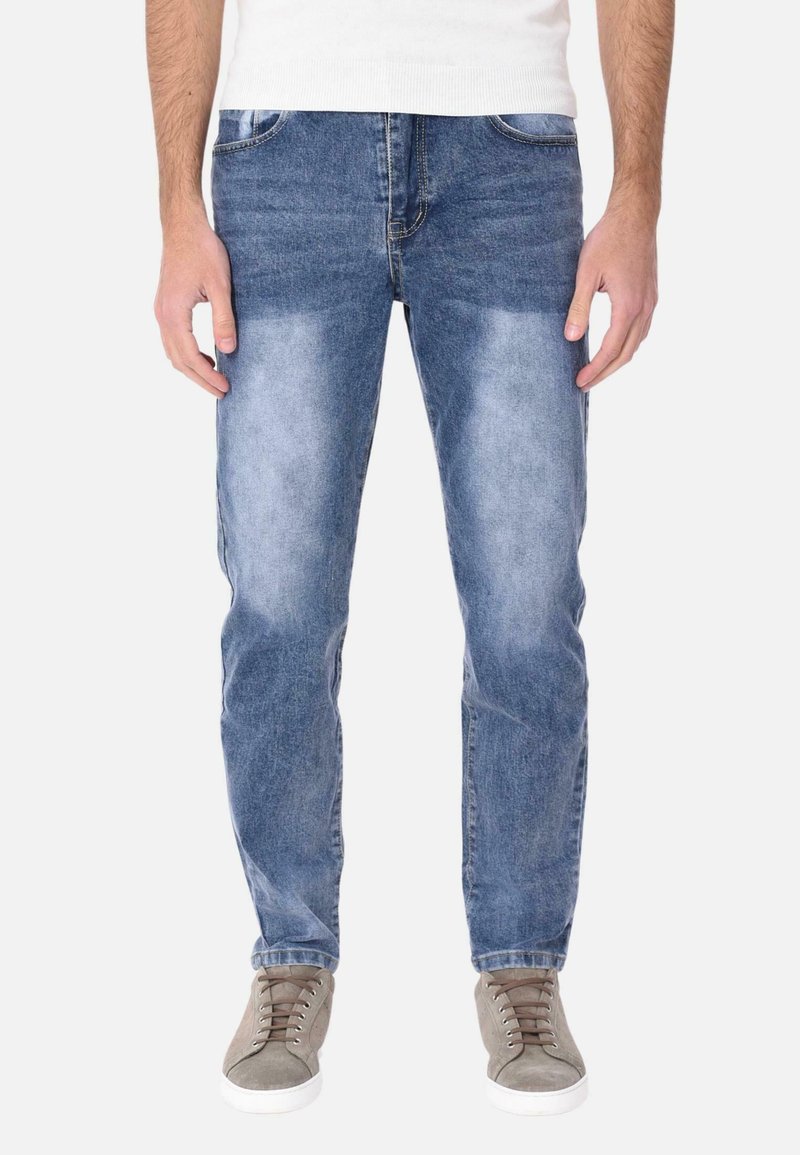 Jeans in denim azzurro chiaro con taglio dritto, zone scolorite, cinque tasche e dettagli cuciti, abbinati a sneakers grigie.