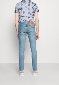 Vaaleansiniset slim-fit farkut, joissa on klassinen viisi-taskun muotoilu, farkkukangas ja merkkipaine takavyötäröllä.