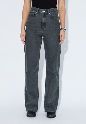 Jeans o wysokim stanie, prostą nogawką w ciemnoszarym deniomie; zawierają miedziane dodatki, pięć kieszeni i luźny krój.