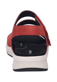 Rote Leder-Sandale mit einer niedrigen weißen Sohle und einem schwarzen strukturierten Fußbett. Verfügt über einen Klettverschluss und ein offenes Rückendesign für ein einfaches An- und Ausziehen.