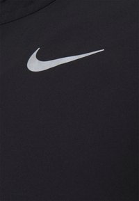 Schwarzer Sportstoff mit glatter Textur, der im oberen linken Bereich ein markantes silbernes Nike-Swoosh-Logo aufweist.