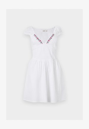 Valge lühike kleit puffyvarrukatega, rõngastega tagakülg, volditud eesmine osa ja lilleseemne tikand sügava V-kaeluse ääres.