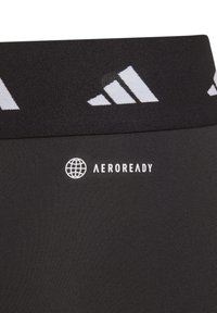 Leggings deportivos negros con tejido transpirable. Cuenta con una cinturilla ancha con el logo blanco de adidas y la marca "AEROREADY". Textura suave.