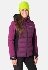 Purple insulated jacket with black accents, zip closure, and cuffs. Worn with a bright green knitted beanie. Solid color, quilted texture.