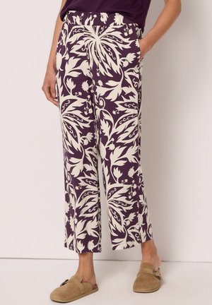 Løse bukser med lige ben med lilla og hvidt blomsterprint, elastisk talje, sidelommer, brugt med brune slip-on sko.