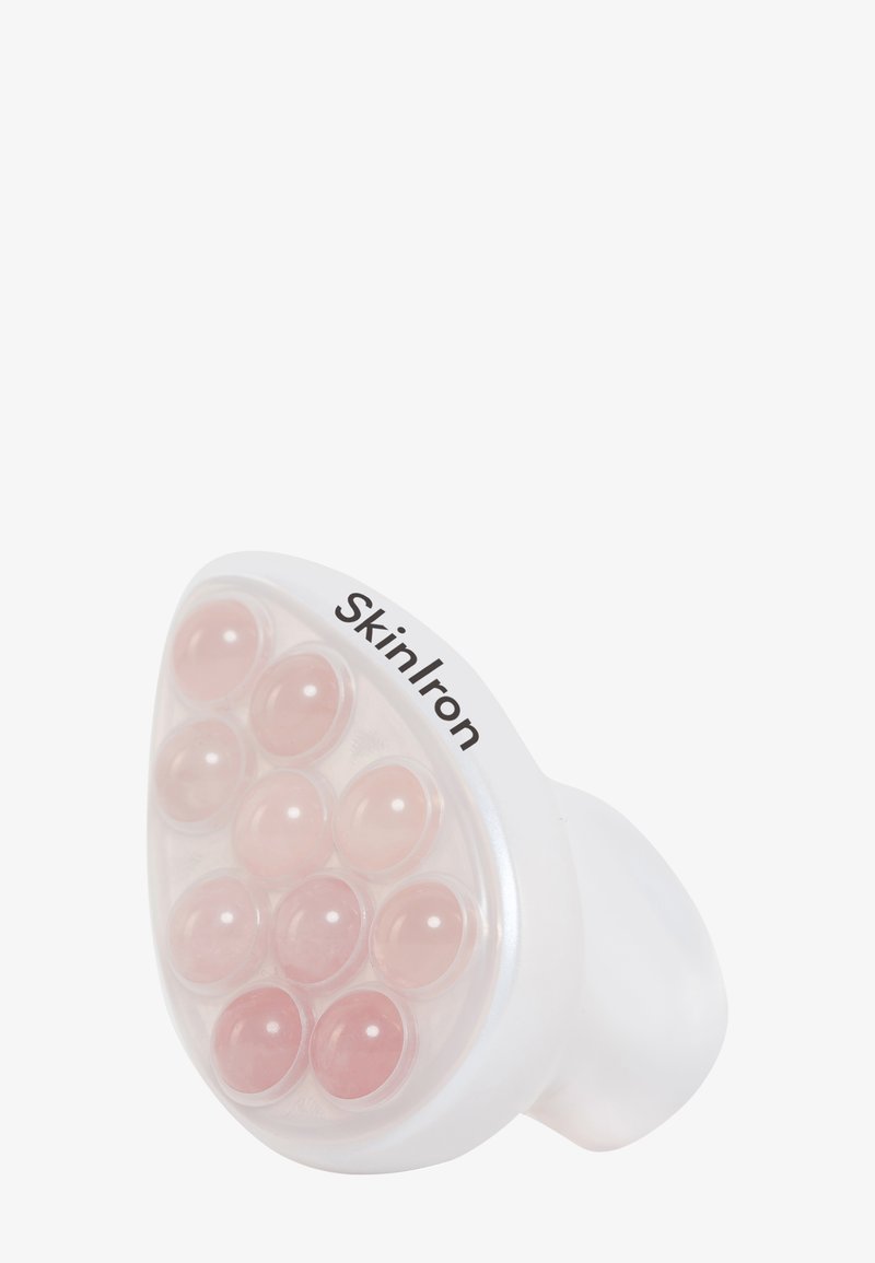 SkinIron ansiktsverktøy med et hvitt plastgrep og et rundet hode som har ti rosa geléaktige kuler for hudbehandling.