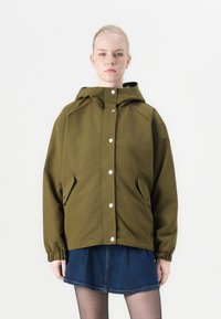Olive green hooded jacket with a relaxed fit, featuring snap buttons and side pockets, paired with a denim skirt. Smooth fabric texture.