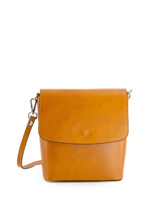 Tan leather crossbody bag with a flap closure, embossed logo, adjustable strap, and smooth texture. Minimalist design with a structured shape.