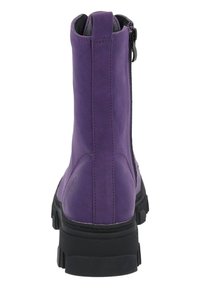 Fioletowy skórzany botek na kostkę z czarną gumową podeszwą, zamkiem błyskawicznym z tyłu i teksturowaną powierzchnią; posiada logo z boku.