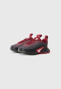 Red and black sneakers featuring a mesh upper, textured patterns, round rubber sole with visible air cushioning, and looped pull tabs.