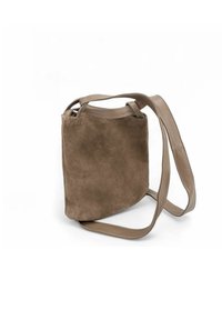 Sac bandoulière en suède marron avec une texture douce, dotée d'une simple sangle ajustable et d'un design épuré et minimaliste.