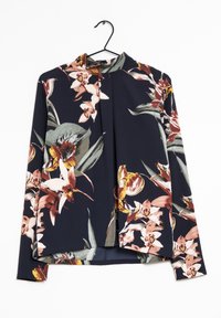 Blusa floreale con sfondo blu navy, caratterizzata da una varietà di fiori in tonalità di rosa, giallo e verde. Maniche lunghe e scollo alto.