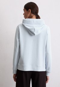 Helleblaue Kapuzenpullover mit lockerer Passform, ausgestattet mit einer Kängurutasche und gerippten Bündchen. Weicher Stoff und minimale Nähte für einen angenehmen Tragekomfort.