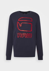Felpa blu navy con scollo a girocollo, caratterizzata da un grande logo "RAW" in rosso e arancione sul davanti. Realizzata in tessuto morbido e strutturato.