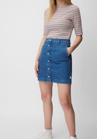 Jupe en denim bleu foncé avec une coupe ajustée, fermeture à boutons sur le devant, poches latérales et un ourlet au-dessus du genou. Accentuée par une étiquette.