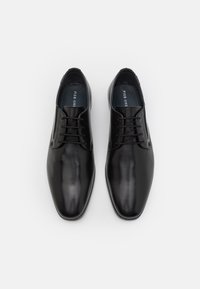 Chaussures de ville en cuir noir avec une finition lisse, bout pointu et un système de laçage à six œillets. L'intérieur est doté d'une doublure bleue.