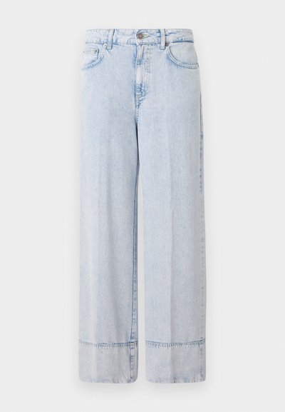 Heledad sinine teksariie laia säärega püksid, millel on kõrge vöökoht. Omab nööbi- ja tõmbluku sulgemist, esimesi taskuid ja toorikuäärist.