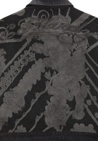 Giubbotto di jeans nero con intricati disegni grigi, tra cui un leone, fiori e motivi vorticosi sulla schiena.
