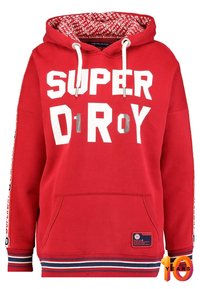 Röd huvtröja med stora vita och silvertexten "SUPERDRY" och "D1ROY." Innehåller sidostrecker med logotyper och en framficka.