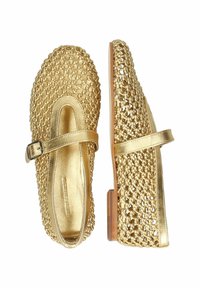Zapatos de oro trenzados con tacón plano, que presentan una correa de hebilla lateral y un forro interior suave. Exterior texturizado con un acabado brillante.